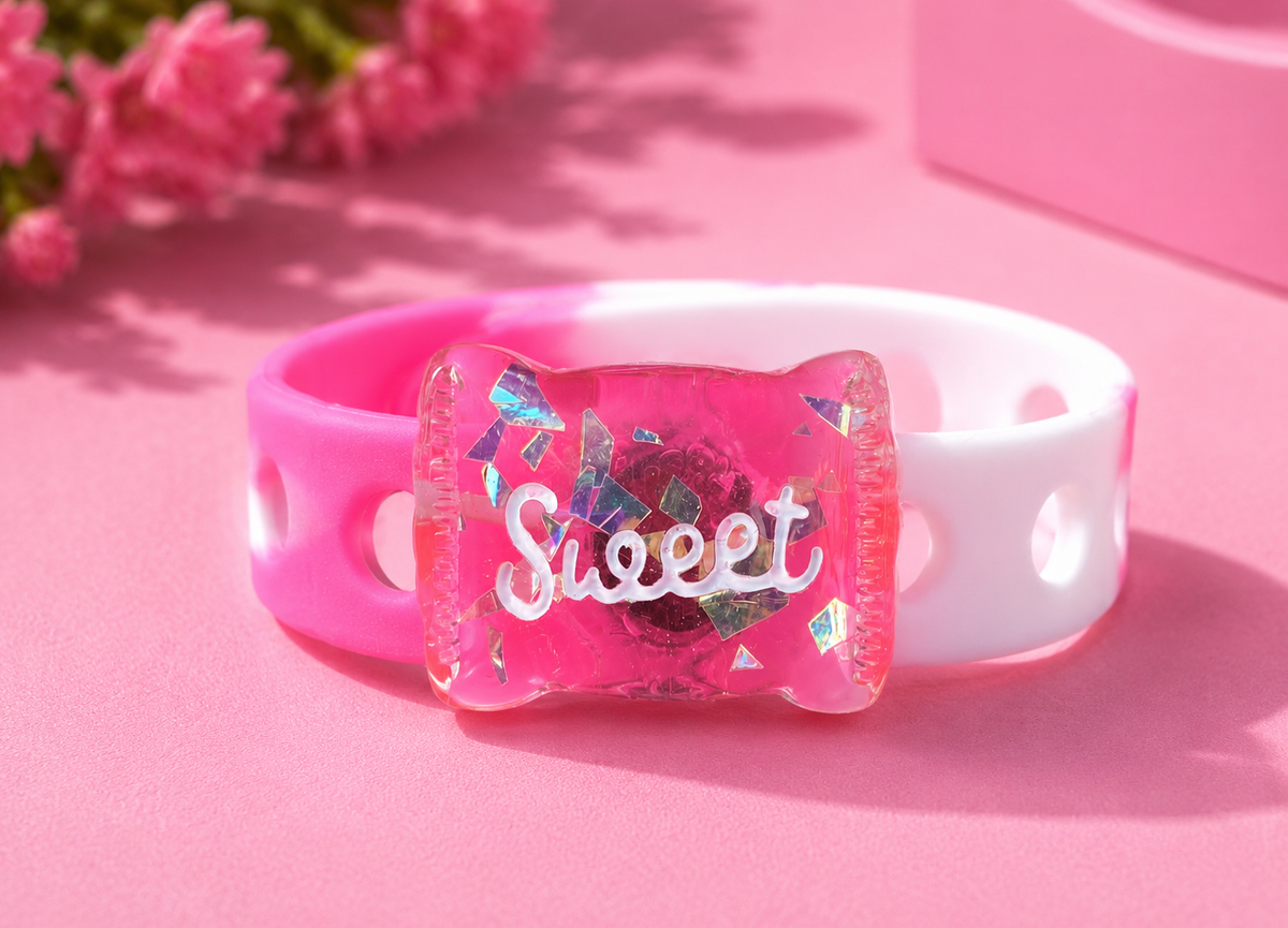 Add sparkle to your style with the Bubblegum Dreams Bracelet. Features a glitter-filled candy charm, pink and white adjustable band, and secure snap-lock closure.